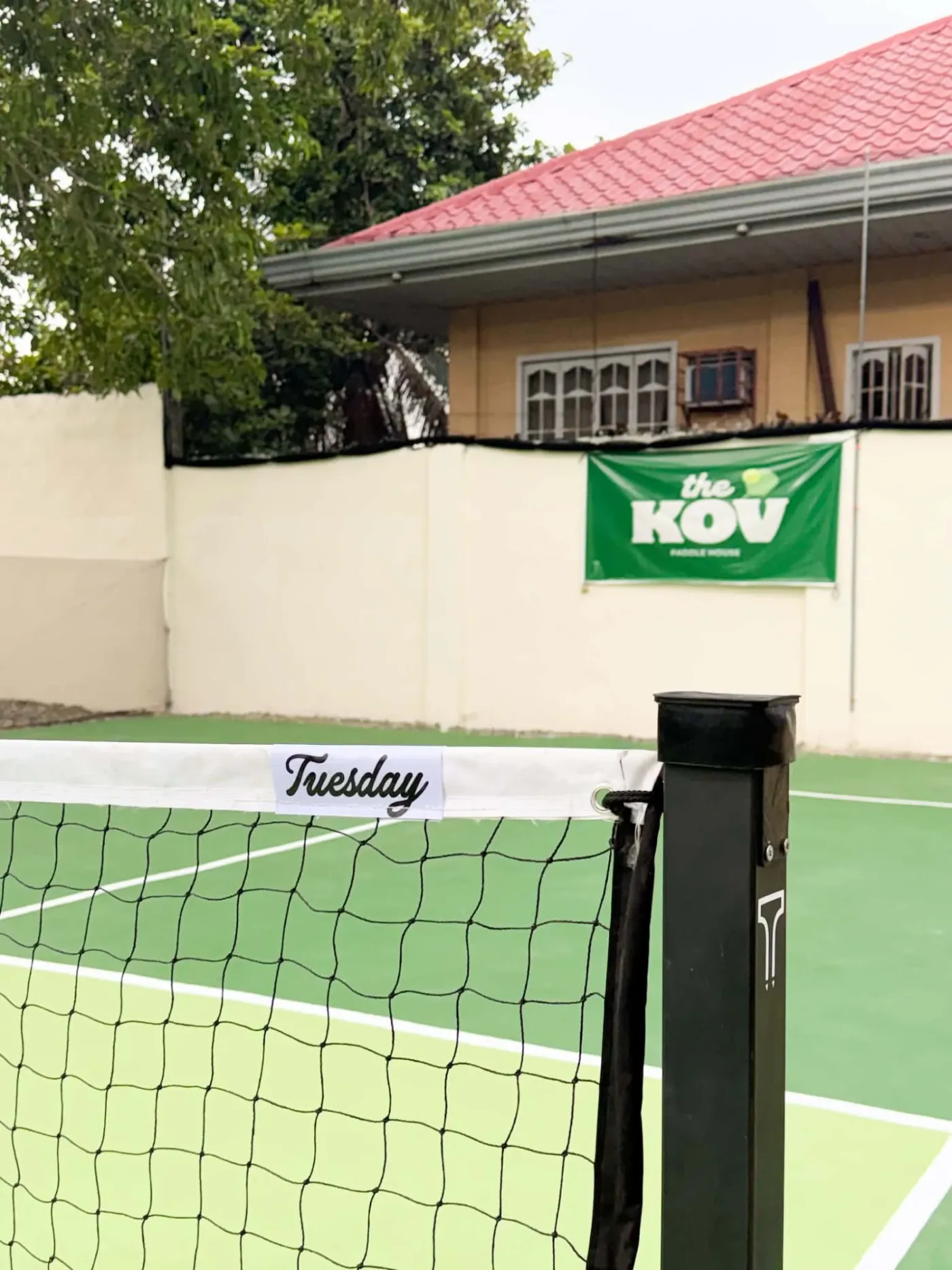 Net post on The Kov's court, with the club's green banner on the wall behind